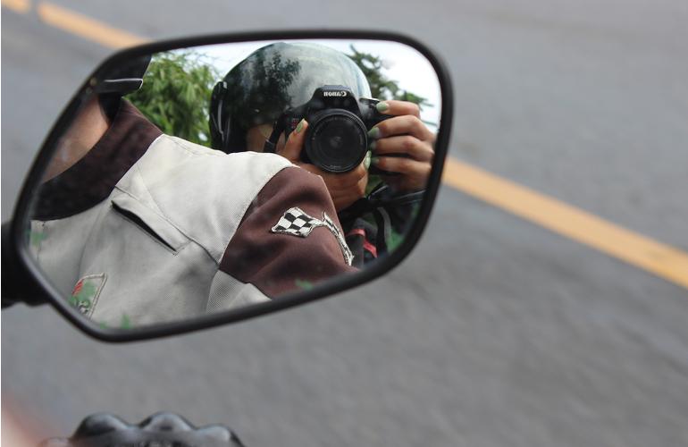 Daniela and Jordan in the reflection of a motorcycle wing mirror